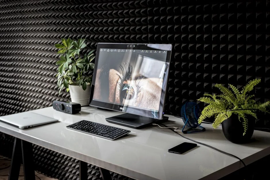 Un espace de travail contemporain avec deux écrans d’ordinateur affichant des projets de conception web, mettant en avant la technologie et la productivité.